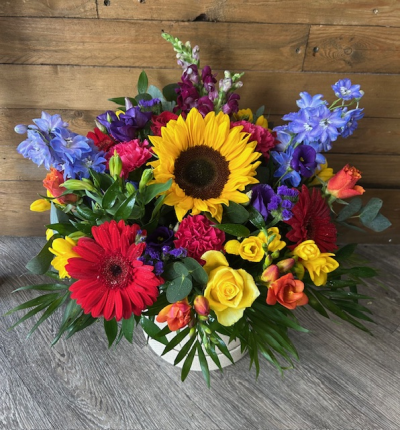 Vibrant Hat Box - A beautiful vibrant hat box arrangement using yellows, oranges, whites, purples etc. Flowers may vary depending on availability. Size shown is medium
