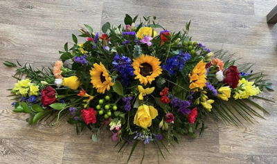 Doube Ended Spray Pink - Double ended spray full of red and pink roses and gerberas and a mix of greenery with blue delphiniums. Flowers may vary according to availability. Includes local delivery.
